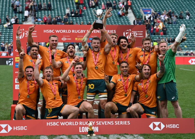 Australia's players celebrate with the trophy after their win in the Cup Final rugby union match between New Zealand and Australia on the second day of the London 2022 World Rugby Sevens Series event at Twickenham Stadium in west London on May 29, 2022. (Photo by Glyn KIRK / AFP)