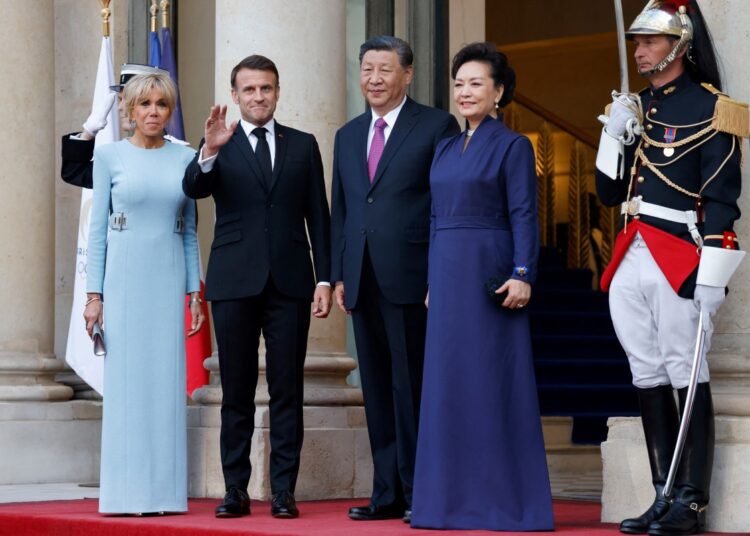 French President Emmanuel Macron (2nd L), his wife Brigitte Macron (L), Chinese President Xi Jinping (2nd R) and his wife Peng Liyuan (R)  pose prior to an official state dinner as part of the Chinese president's two-day state visit to France, at the Elysee Palace in Paris, on May 6, 2024. - The French president hosts his Chinese counterpart for a state visit on May 6, 2024, seeking to persuade the Chinese leader to shift positions over Russia's invasion of Ukraine and also imbalances in global trade. (Photo by Ludovic MARIN / AFP)