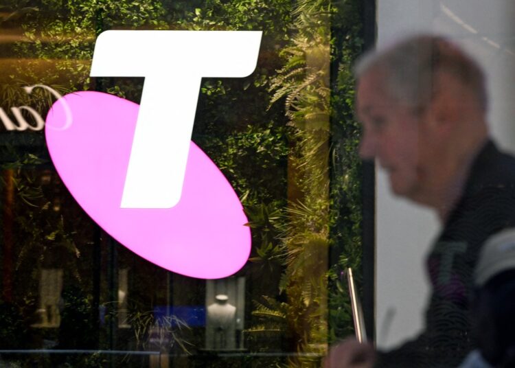 A man walks past the office of Australian telecoms company Telstra in the central business district of Sydney on May 21, 2024. - Leading Australian telecoms company Telstra said May 21 it would slash up to 2,800 jobs, shedding nine percent of its workforce as it keeps pace with "rapid advances in technology". (Photo by Saeed KHAN / AFP)