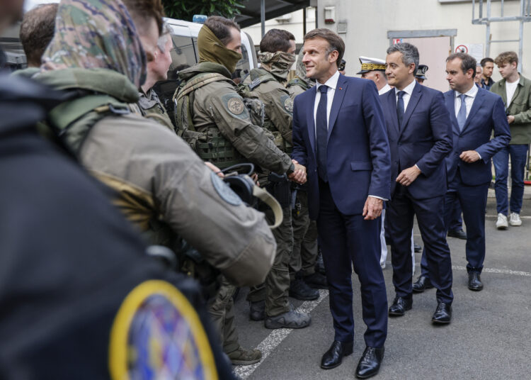 French President Emmanuel Macron visits the central police station in Noumea, France's Pacific territory of New Caledonia on May 23, 2024. - France's president made a long-haul trip to the restive Pacific territory of New Caledonia on on May 23, urging a "return to peace" after deadly rioting, and vowing thousands of military reinforcements will be deployed for "as long as necessary". (Photo by Ludovic MARIN / POOL / AFP)
