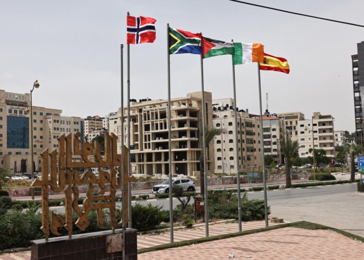 The flags of (L-R) Norway, South Africa, Palestine, Ireland, and Spain, are raised at an entrance of Ramallah city in the occupied West Bank on May 28, 2024. - Israel's war in Gaza since the October 7 attack has revived a global push for Palestinian statehood, with Norway, Spain and Ireland on May 28 becoming the latest to recognise a state of Palestine, in a move which has infuriated Israel, and brought to 145 the number of UN member states out of 193 to have done so. (Photo by Zain JAAFAR / AFP)