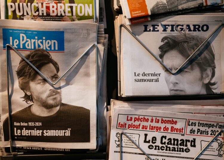 This photograph shows the front pages of French newspapers showing the news of the death of French actor Alain Delon, in Paris, on August 19, 2024. - French film legend Alain Delon died at the age of 88, his three children told AFP in a statement on August 18, 2024, following a battle with ill health. (Photo by Dimitar DILKOFF / AFP)